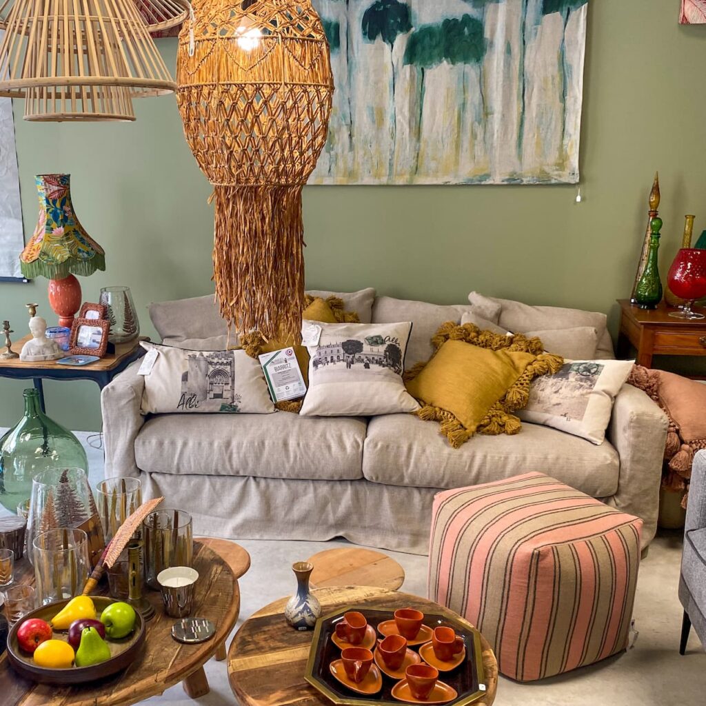 Canapé en lin avec coussins et poufs à rayures dans la boutique déco de Ma Bicoque à Albi