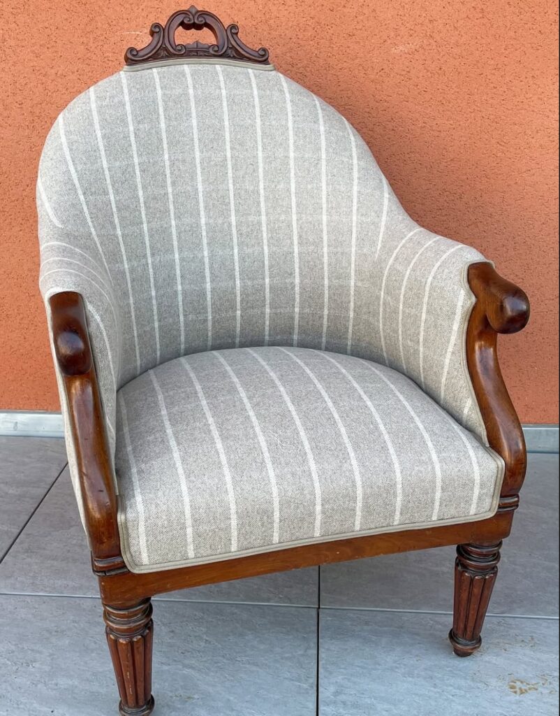 Fauteuil crapaud ancien à dossier tonneau regarni d'un lainage gris à fines rayures, tapissier à Albi
