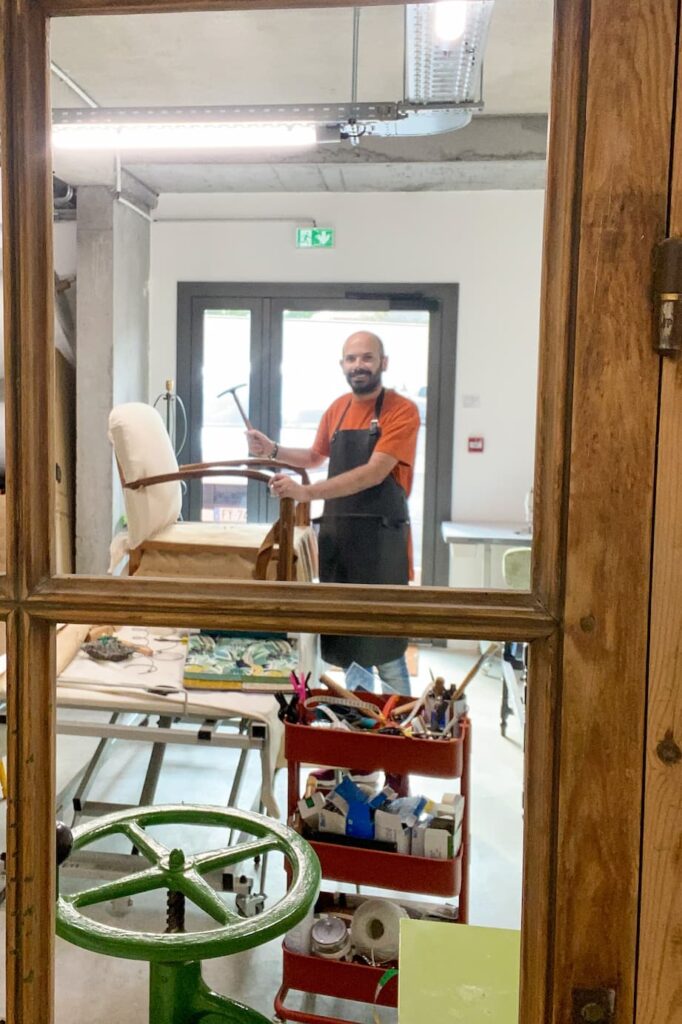 Le tapissier Laurent Assié au travail sur un fauteuil dans son atelier à Albi