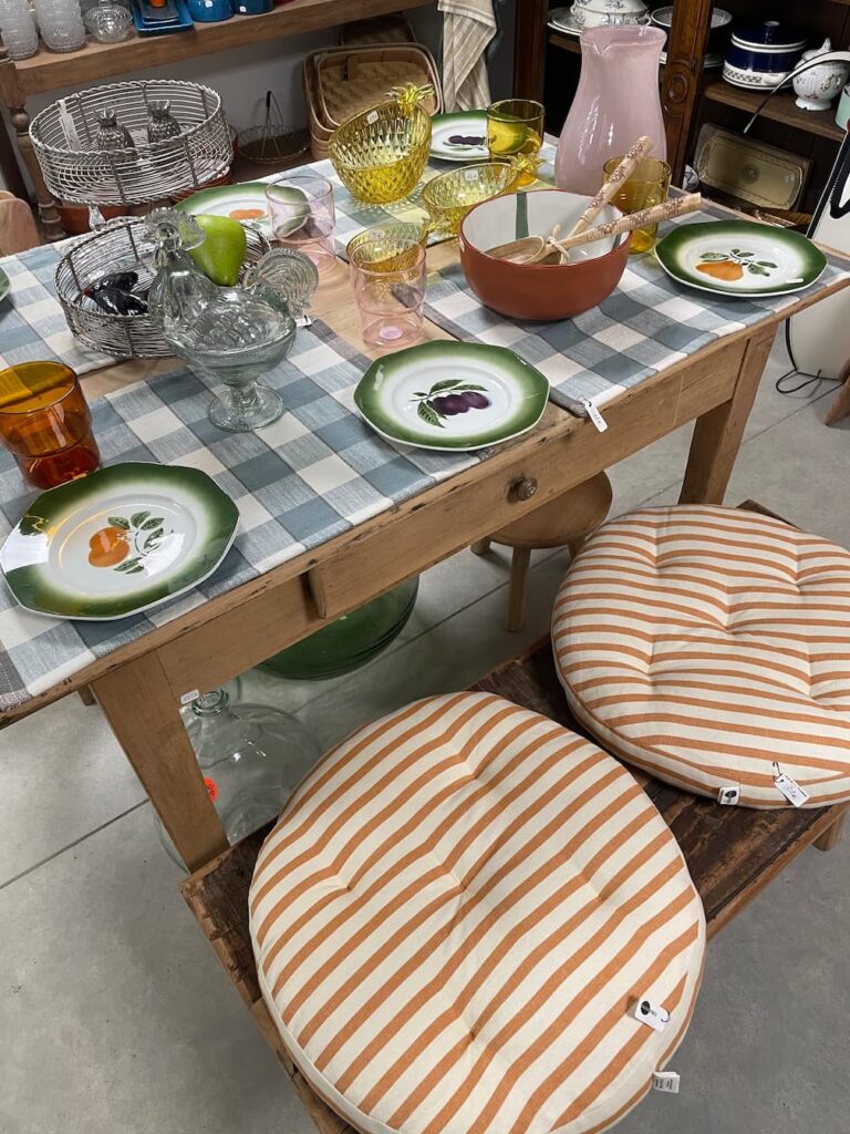 Galettes de chaise rondes rayées terracotta et vaisselle vintage dans la boutique déco d'Albi